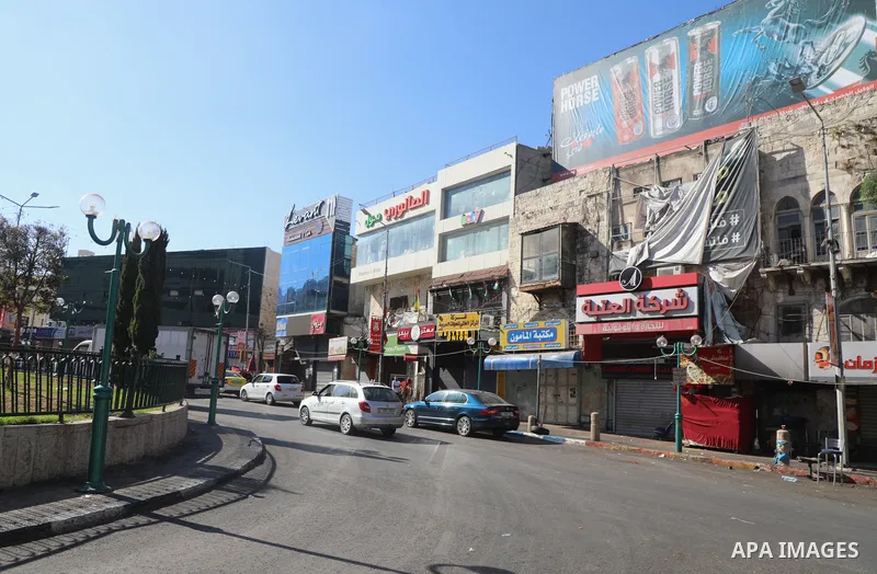 Palestinians walk near closed shops during a general strike, after Israeli forces killed Two Palestinians, in the West Bank city of Nablus on July 24, 2022. Two Palestinians were shot dead last night and ten others wound...