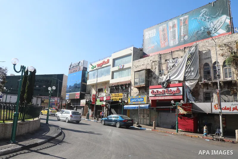 Palestinians walk near closed shops during a general strike, after Israeli forces killed Two Palestinians, in the West Bank city of Nablus on July 24, 2022. Two Palestinians were shot dead last night and ten others wound...