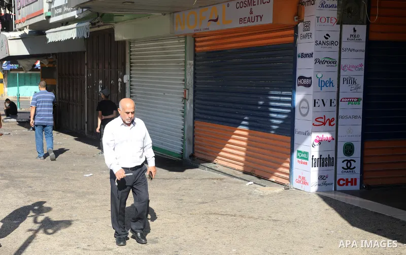 Palestinians walk near closed shops during a general strike, after Israeli forces killed Two Palestinians, in the West Bank city of Nablus on July 24, 2022. Two Palestinians were shot dead last night and ten others wound...