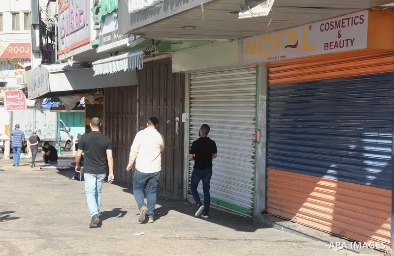 Palestinians walk near closed shops during a general strike, after Israeli forces killed Two Palestinians, in the West Bank city of Nablus on July 24, 2022. Two Palestinians were shot dead last night and ten others wound...