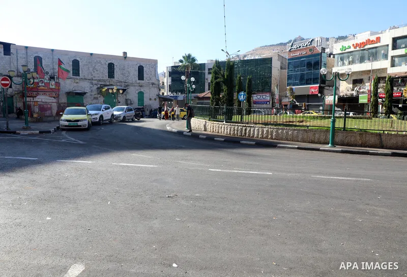Palestinians walk near closed shops during a general strike, after Israeli forces killed Two Palestinians, in the West Bank city of Nablus on July 24, 2022. Two Palestinians were shot dead last night and ten others wound...