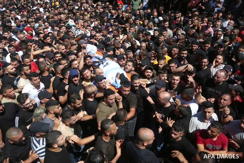 Mourners carry the bodies of two Palestinians who were killed by Israeli forces, during their funeral, in the West Bank city of Nablus on July 24, 2022. Two Palestinians were shot dead last night and ten others wounded,...