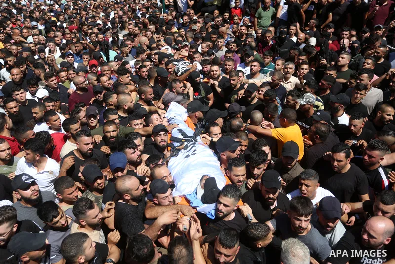 Mourners carry the bodies of two Palestinians who were killed by Israeli forces, during their funeral, in the West Bank city of Nablus on July 24, 2022. Two Palestinians were shot dead last night and ten others wounded,...