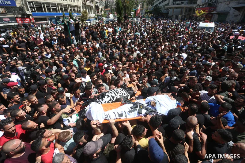 Mourners carry the bodies of two Palestinians who were killed by Israeli forces, during their funeral, in the West Bank city of Nablus on July 24, 2022. Two Palestinians were shot dead last night and ten others wounded,...