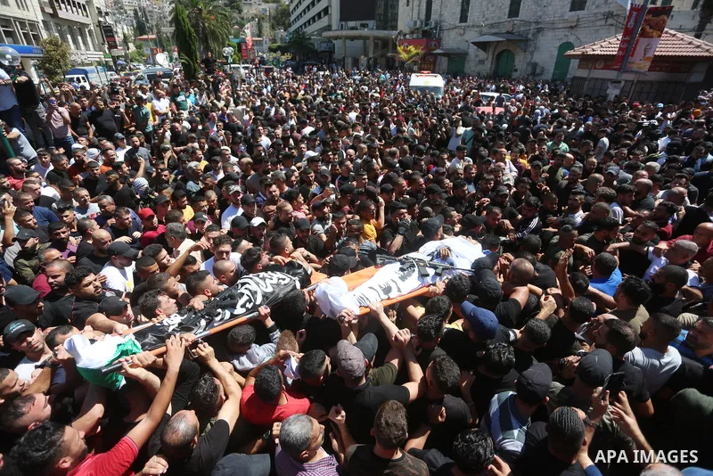 Mourners carry the bodies of two Palestinians who were killed by Israeli forces, during their funeral, in the West Bank city of Nablus on July 24, 2022. Two Palestinians were shot dead last night and ten others wounded,...