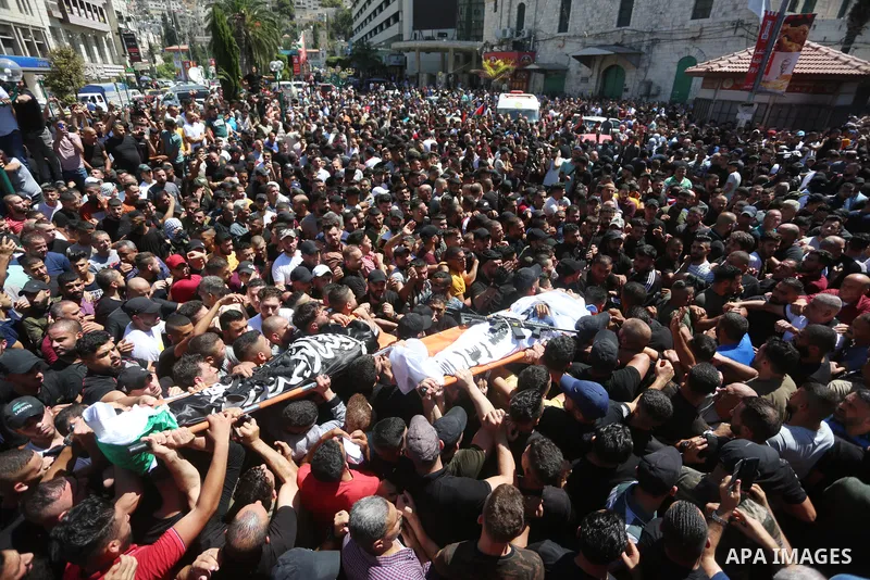 Mourners carry the bodies of two Palestinians who were killed by Israeli forces, during their funeral, in the West Bank city of Nablus on July 24, 2022. Two Palestinians were shot dead last night and ten others wounded,...