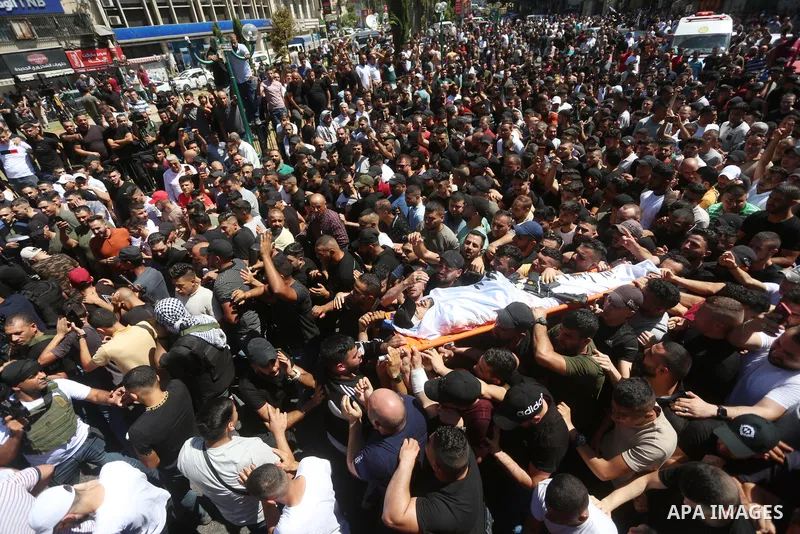 Mourners carry the bodies of two Palestinians who were killed by Israeli forces, during their funeral, in the West Bank city of Nablus on July 24, 2022. Two Palestinians were shot dead last night and ten others wounded,...
