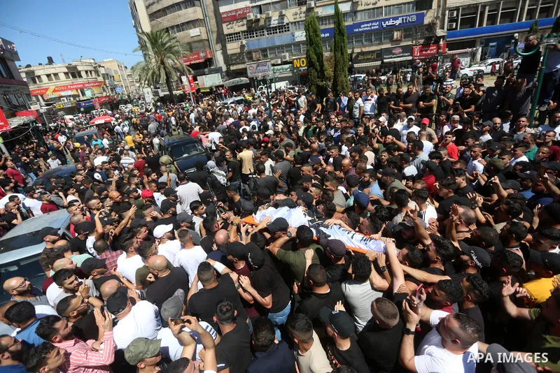 Mourners carry the bodies of two Palestinians who were killed by Israeli forces, during their funeral, in the West Bank city of Nablus on July 24, 2022. Two Palestinians were shot dead last night and ten others wounded,...