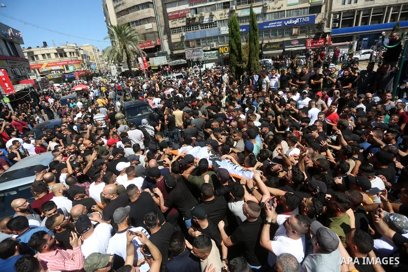 Mourners carry the bodies of two Palestinians who were killed by Israeli forces, during their funeral, in the West Bank city of Nablus on July 24, 2022. Two Palestinians were shot dead last night and ten others wounded,...