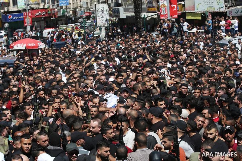 Mourners carry the bodies of two Palestinians who were killed by Israeli forces, during their funeral, in the West Bank city of Nablus on July 24, 2022. Two Palestinians were shot dead last night and ten others wounded,...
