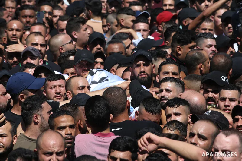 Mourners carry the bodies of two Palestinians who were killed by Israeli forces, during their funeral, in the West Bank city of Nablus on July 24, 2022. Two Palestinians were shot dead last night and ten others wounded,...