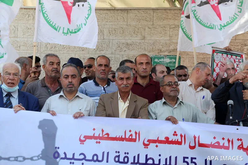 Palestinian supporters of of the popular struggle front, take part in a protest marking the 55th anniversary of its founding, in front of the headquarters of the Red Cross in Gaza City on 25 July 2022. Some 75 Palestinia...
