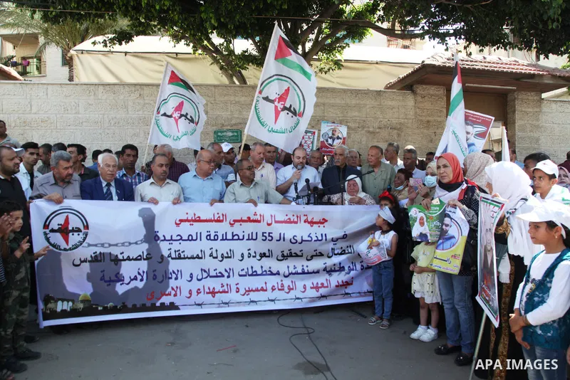 Palestinian supporters of of the popular struggle front, take part in a protest marking the 55th anniversary of its founding, in front of the headquarters of the Red Cross in Gaza City on 25 July 2022. Some 75 Palestinia...