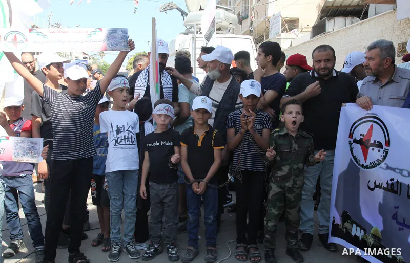 Palestinian supporters of of the popular struggle front, take part in a protest marking the 55th anniversary of its founding, in front of the headquarters of the Red Cross in Gaza City on 25 July 2022. Some 75 Palestinia...