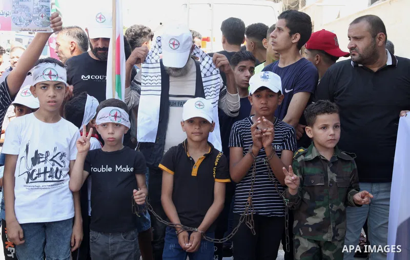 Palestinian supporters of of the popular struggle front, take part in a protest marking the 55th anniversary of its founding, in front of the headquarters of the Red Cross in Gaza City on 25 July 2022. Some 75 Palestinia...