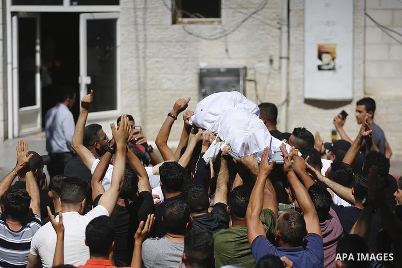 Mourners carry the body of Palestinian teenager Amjad Abu Alia, who was killed following clashes with the Israeli army outside a hospital, in the West Bank city of Ramallah on July 29, 2022. Abu Alia, 16, "died of critic...