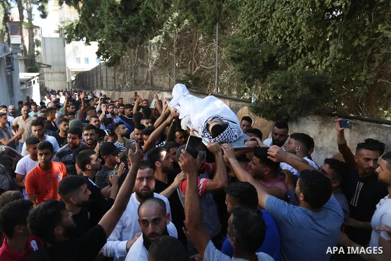 Mourners carry the body of Palestinian teenager Amjad Abu Alia, who was killed following clashes with the Israeli army outside a hospital, in the West Bank city of Ramallah on July 29, 2022. Abu Alia, 16, "died of critic...