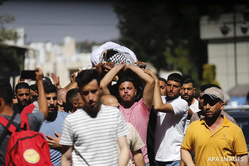 Mourners carry the body of Palestinian teenager Amjad Abu Alia, who was killed following clashes with the Israeli army outside a hospital, in the West Bank city of Ramallah on July 29, 2022. Abu Alia, 16, "died of critic...