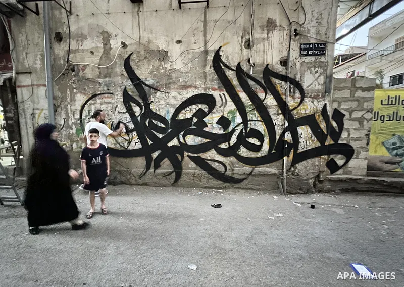 Palestinian artist Bilal Khaled draws on a wall a graffiti mural "In the name of the camp, I did not die and ask Jenin", in Burj al-Barajneh refugee camp, a Palestinian refugee camp in Beirut on June 10, 2022. Photo by N...