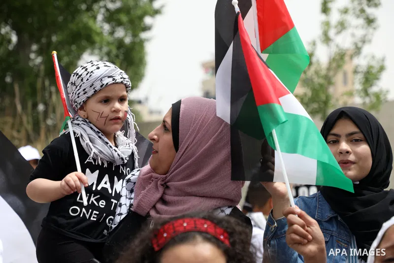 Palestinians wave national flags as they march in a rally marking the 74th anniversary of the "Nakba" or "catastrophe", in the West Bank city of Ramallah, on May 15, 2022. Each year Palestinians commemorate the "Nakba" o...
