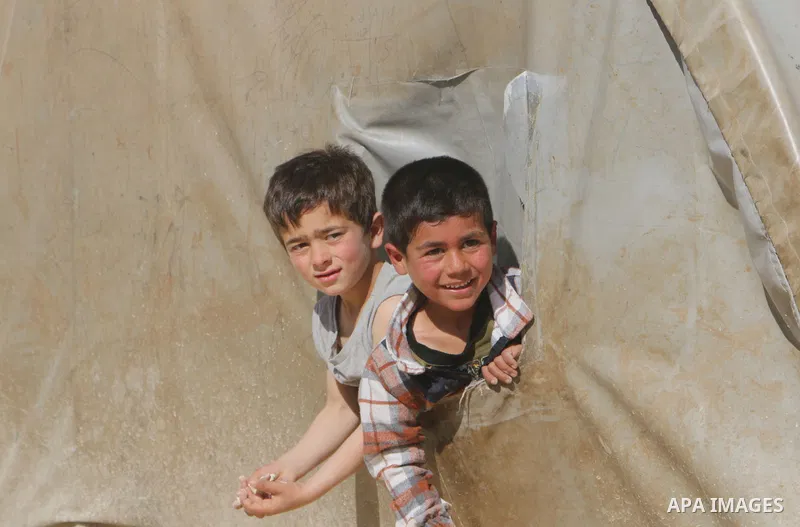 Syrian refugees play near their tents during the Muslims holy month of Ramadan, at Awtad camp north of Azaz on Syria's northern border with Turkey, on April 19, 2022. Photo by Samir Abed