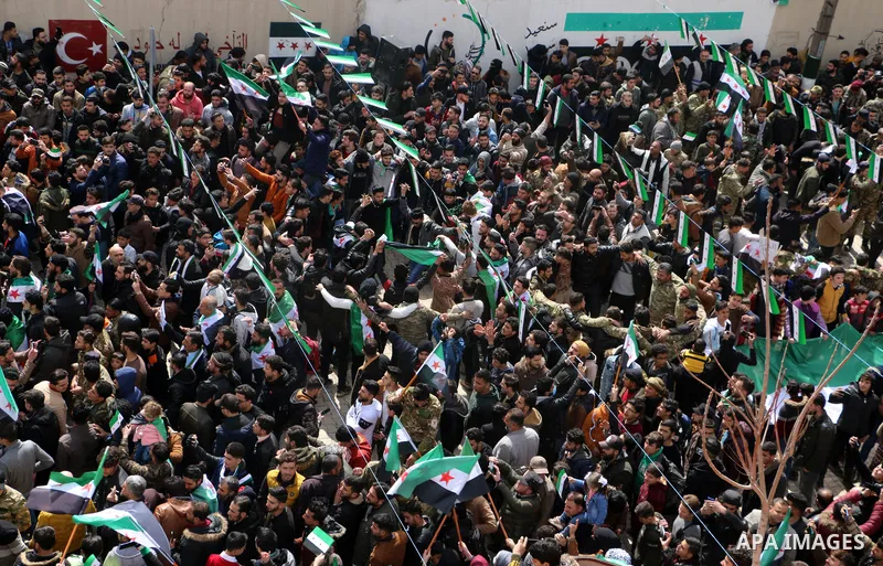 Syrians chant and hold banners during a rally marking 11 years since the start of an anti-regime uprising in the city of Azaz, northern countryside of Syria's Aleppo province, on March 15, 2022. Photo by Samir Abed