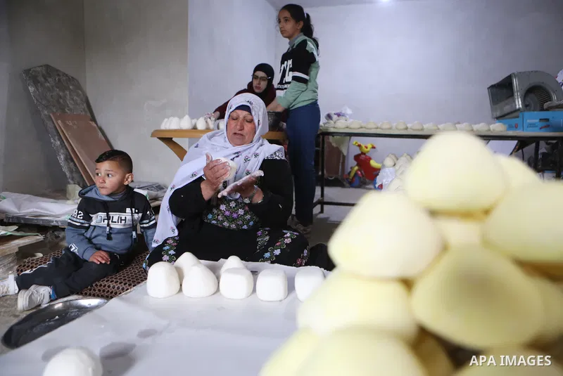 Palestinian family make Jameed in Masafer Yatta, south of Hebron, in the southern West Bank on March 23, 2022. Jameed dry fermented yogurt made from ewe or goat's milk. Jameed is the primary ingredient used to make mansa...