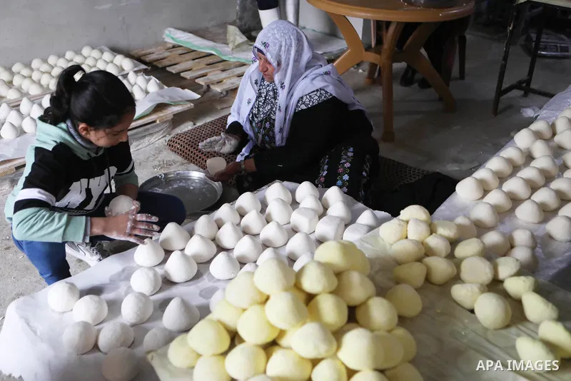 Palestinian family make Jameed in Masafer Yatta, south of Hebron, in the southern West Bank on March 23, 2022. Jameed dry fermented yogurt made from ewe or goat's milk. Jameed is the primary ingredient used to make mansa...