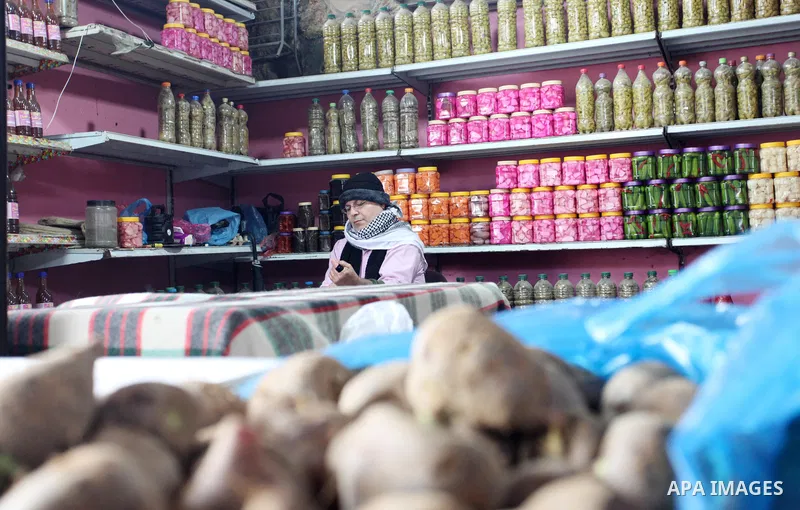 Palestinian man Amin Abu al-Kas, 57, prepares vegetables for cooking at his shop in the Firas popular market in Gaza City, on January 30, 2022. Abu al-Kas makes a living by making prepares vegetables and selling them for...