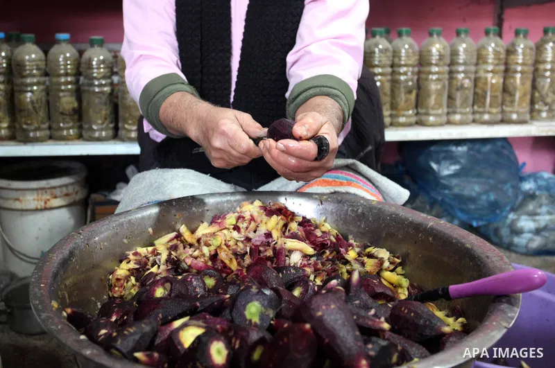 Palestinian man Amin Abu al-Kas, 57, prepares vegetables for cooking at his shop in the Firas popular market in Gaza City, on January 30, 2022. Abu al-Kas makes a living by making prepares vegetables and selling them for...