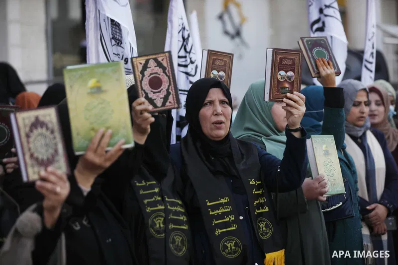 Palestinians hold Koran during a protest the burning of a copy of the Muslim holy book of Koran by a far-right politician Outside the Turkish Embassy in Stockholm in the Nuseirat refugee camp in the central Gaza Strip on...