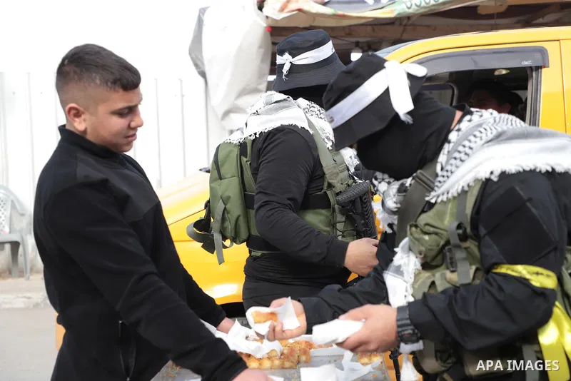 Militants from the Al-Aqsa Martyrs Brigades, the military wing of Fatah movement, distribute sweets celebrating following reports that two Israeli shot and wounded in a shooting attack in Silwan neighborhood, in the West...