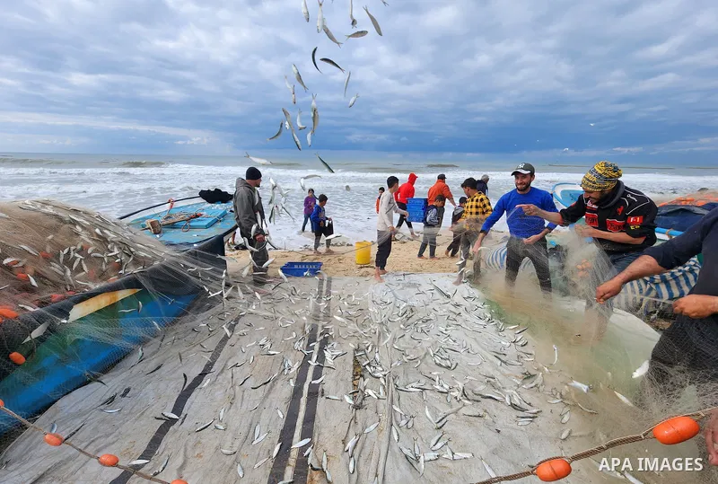 Palestinian fishermen carry their day's catch following a stormy weather on the beach of Deir al-Balah in the southern of Gaza strip on Feb. 09, 2023. Photo by Ashraf Amra\ apaimages
