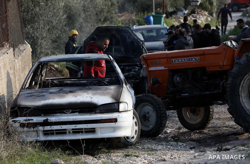 Palestinians inspect a car set on fire by Jewish settlers in in Burin village in the West Bank city of Nablus on February 25, 2023. Hardcore Israeli settlers today attacked Palestinians' homes in the village of Burin in...