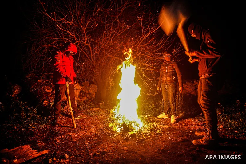March 1, 2023, Nablus, West Bank, Palestine: Masked Palestinians carrying wooden sticks around the fire stand on guard during the night to fend off attacks by the Jewish settlers, south of Nablus in the West Bank. Settle...
