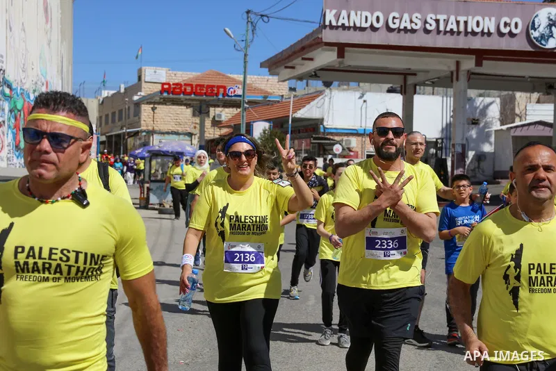 Participants run past a section of Israel's controversial separation barrier during the "Freedom of Movement Palestine Marathon" in Bethlehem in the West Bank on March 10, 2023. Photo by Ahmad Tayem/APAimages