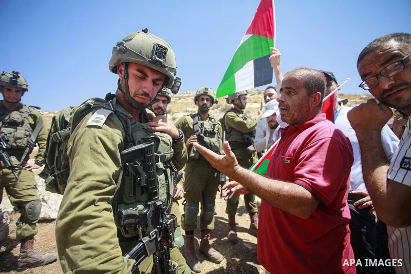 Palestinians argue with Israeli forces during a protest against the establishment of Israeli outposts, in Beit Dajan, east of the West Bank, city of Nablus, on August 11, 2023. Photo by Mohammed Nasser