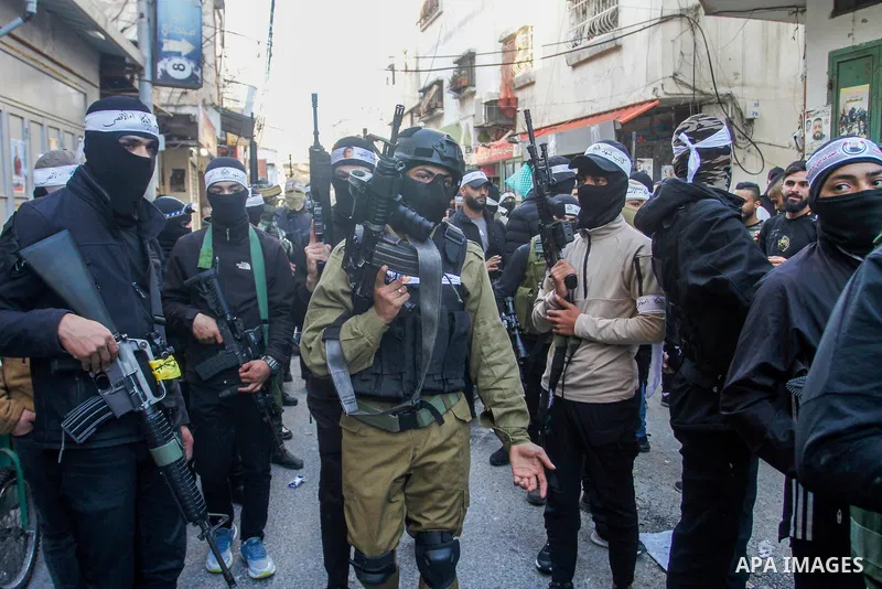 Palestinian gunmen of the Al-Aqsa Martyrs Brigades faction affiliated with the Fateh movement, hold their weapons during a military parade, in the Balata refugee camp in the West Bank city of Nablus on March 17, 2023. Ph...