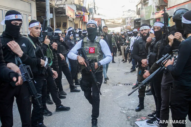 Palestinian gunmen of the Al-Aqsa Martyrs Brigades faction affiliated with the Fateh movement, hold their weapons during a military parade, in the Balata refugee camp in the West Bank city of Nablus on March 17, 2023. Ph...