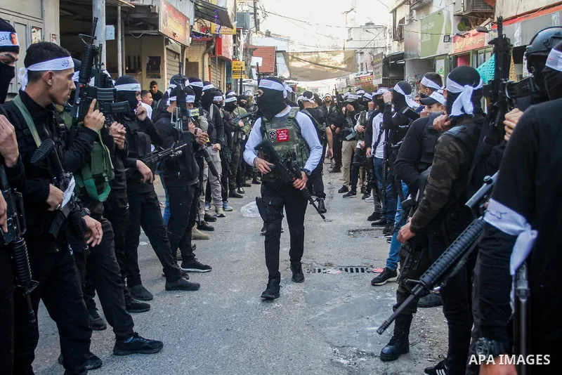 Palestinian gunmen of the Al-Aqsa Martyrs Brigades faction affiliated with the Fateh movement, hold their weapons during a military parade, in the Balata refugee camp in the West Bank city of Nablus on March 17, 2023. Ph...