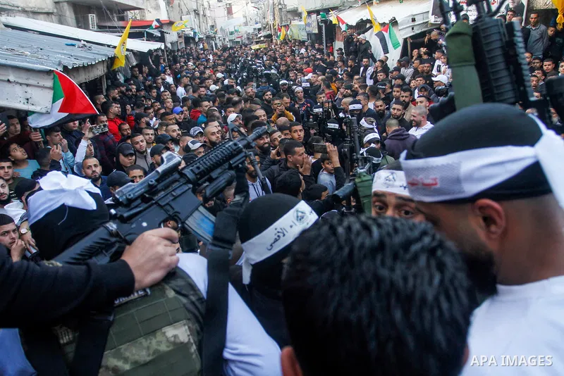 Palestinian gunmen of the Al-Aqsa Martyrs Brigades faction affiliated with the Fateh movement, hold their weapons during a military parade, in the Balata refugee camp in the West Bank city of Nablus on March 17, 2023. Ph...