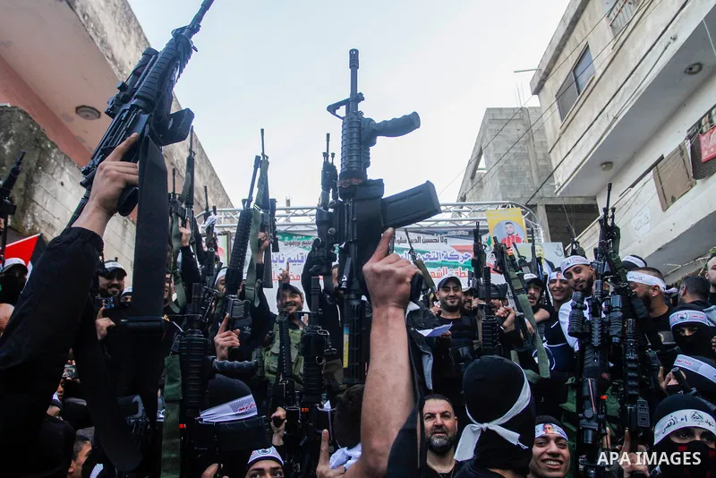 Palestinian gunmen of the Al-Aqsa Martyrs Brigades faction affiliated with the Fateh movement, hold their weapons during a military parade, in the Balata refugee camp in the West Bank city of Nablus on March 17, 2023. Ph...