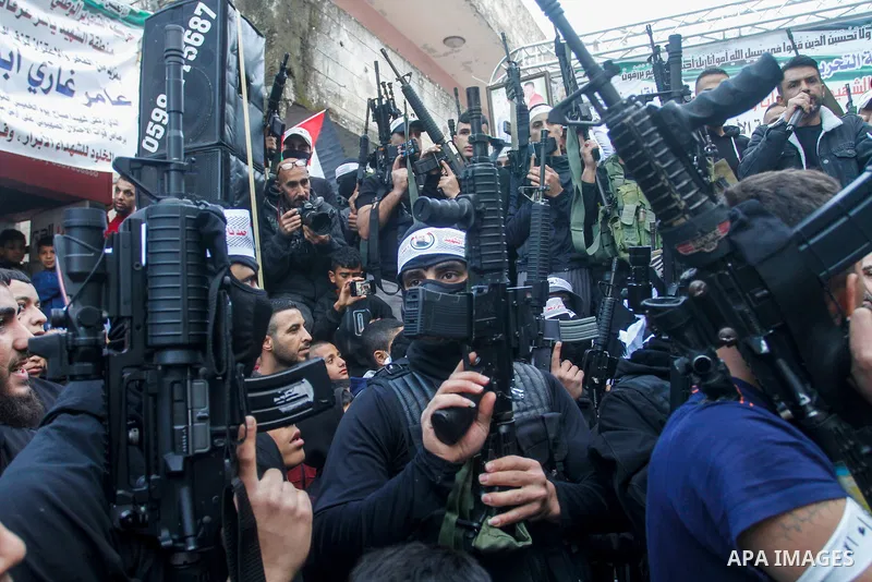 Palestinian gunmen of the Al-Aqsa Martyrs Brigades faction affiliated with the Fateh movement, hold their weapons during a military parade, in the Balata refugee camp in the West Bank city of Nablus on March 17, 2023. Ph...