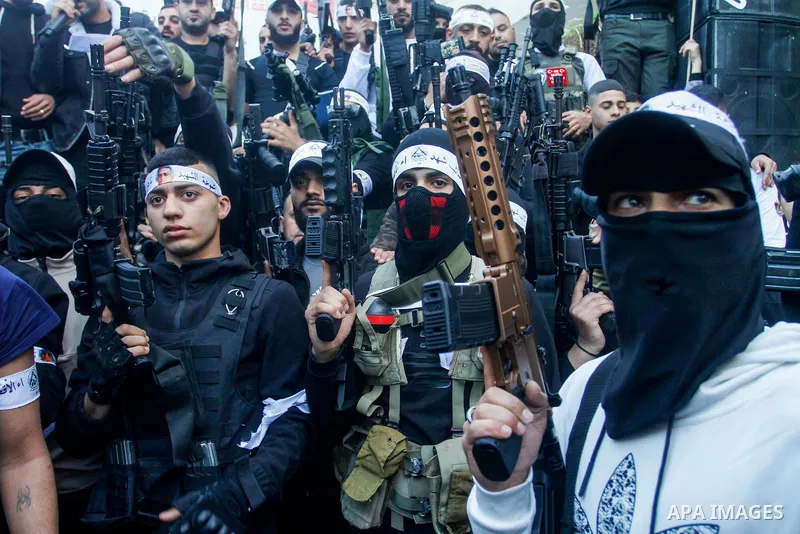 Palestinian gunmen of the Al-Aqsa Martyrs Brigades faction affiliated with the Fateh movement, hold their weapons during a military parade, in the Balata refugee camp in the West Bank city of Nablus on March 17, 2023. Ph...