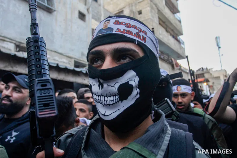 Palestinian gunmen of the Al-Aqsa Martyrs Brigades faction affiliated with the Fateh movement, hold their weapons during a military parade, in the Balata refugee camp in the West Bank city of Nablus on March 17, 2023. Ph...
