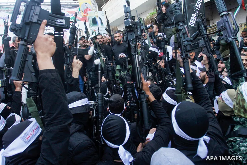 Palestinian gunmen of the Al-Aqsa Martyrs Brigades faction affiliated with the Fateh movement, hold their weapons during a military parade, in the Balata refugee camp in the West Bank city of Nablus on March 17, 2023. Ph...