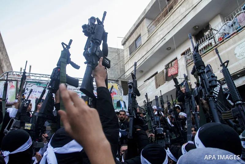 Palestinian gunmen of the Al-Aqsa Martyrs Brigades faction affiliated with the Fateh movement, hold their weapons during a military parade, in the Balata refugee camp in the West Bank city of Nablus on March 17, 2023. Ph...