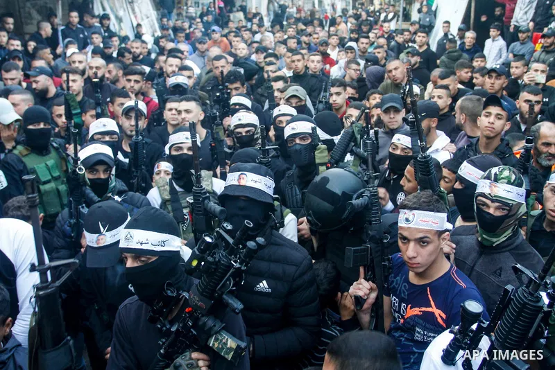 Palestinian gunmen of the Al-Aqsa Martyrs Brigades faction affiliated with the Fateh movement, hold their weapons during a military parade, in the Balata refugee camp in the West Bank city of Nablus on March 17, 2023. Ph...