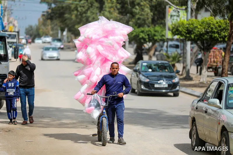 A Palestinian man sells cotton candy on the street in Gaza City on March 18, 2023. Photo by Atia Darwish