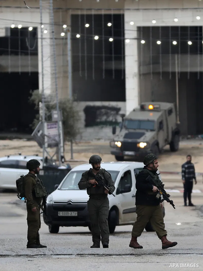Israeli soldiers gather at a checkpoint at the entrance of the Palestinian town of Huwara, in the occupied West Bank, following a reported shooting attack on an Israeli car, on March 19, 2023. The shooting attack in the...